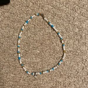 red gold and white necklace with cross charm